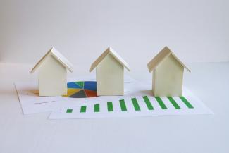 three small houses sitting on top of a piece of paper by BuyandRent Homes courtesy of Unsplash.