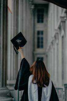 a woman in a graduation cap and gown by Albert Vincent Wu courtesy of Unsplash.